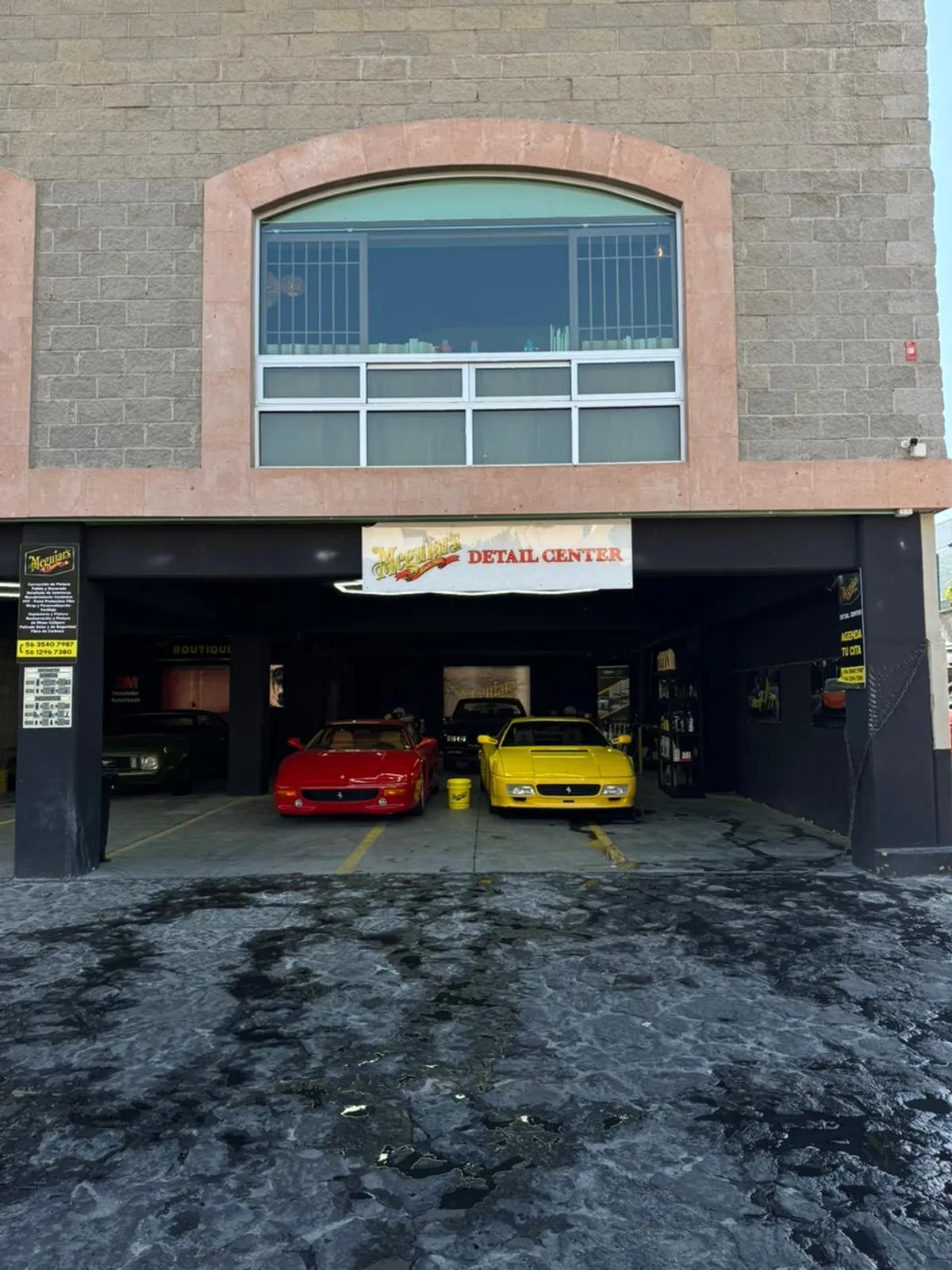 Fachada de Meguiars Detail Center con dos Ferrari 355, rojo y amarillo, recién encerados