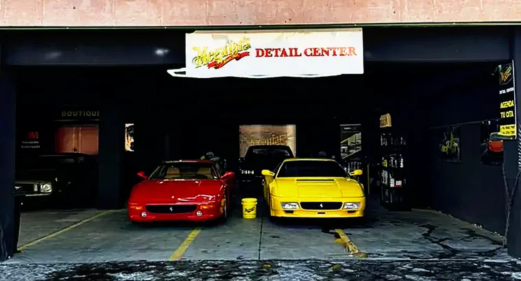 Entrada de la sucursal Periférico Sur con dos Ferrari 355 en la bahía de detallado